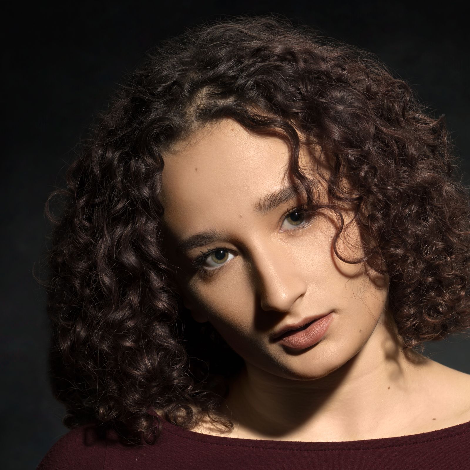 Woman with a natural, confident smile in soft studio light