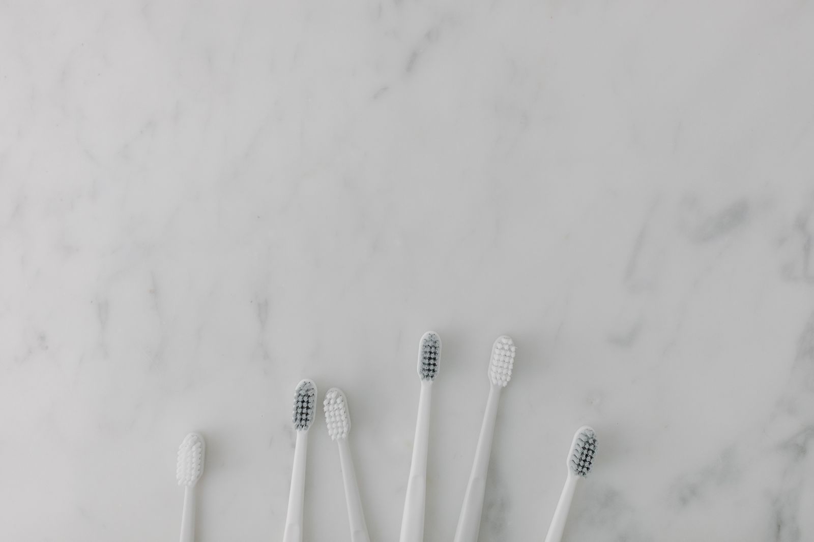 Minimal toothbrushes arranged on a marble surface